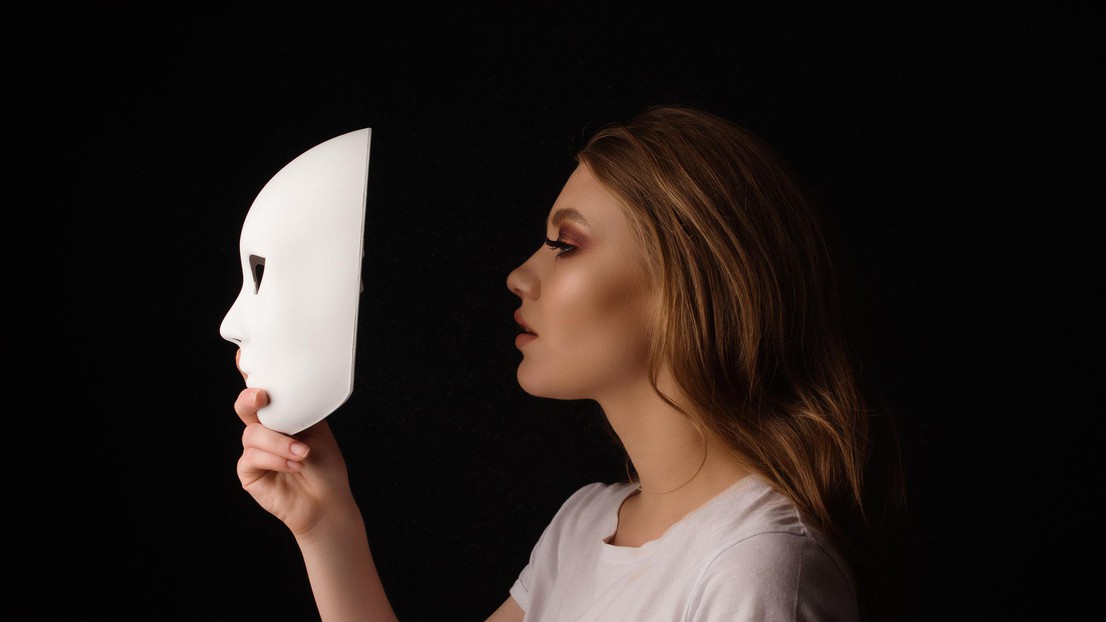 Woman hiding behind white mask © iStock / EPFL 2021