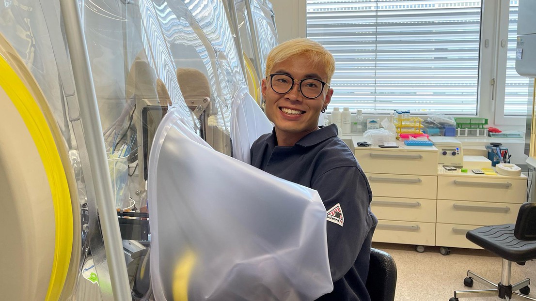 Jeremy Wong working at an anaerobic gas tight chamber, where he gros bacterial biofilms © J. Wong 2021 EPFL