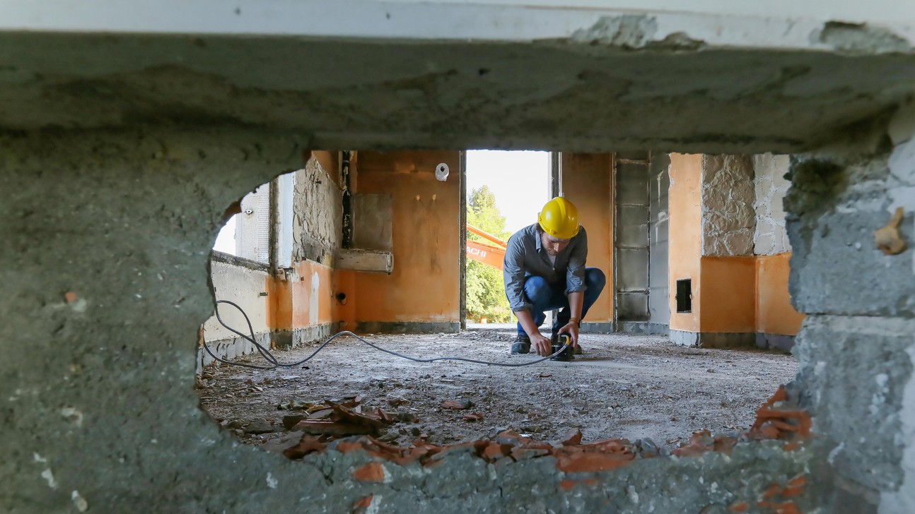 Yves Reuland installs a sensor in a pilot building slated for demolition. © A. Herzog, EPFL