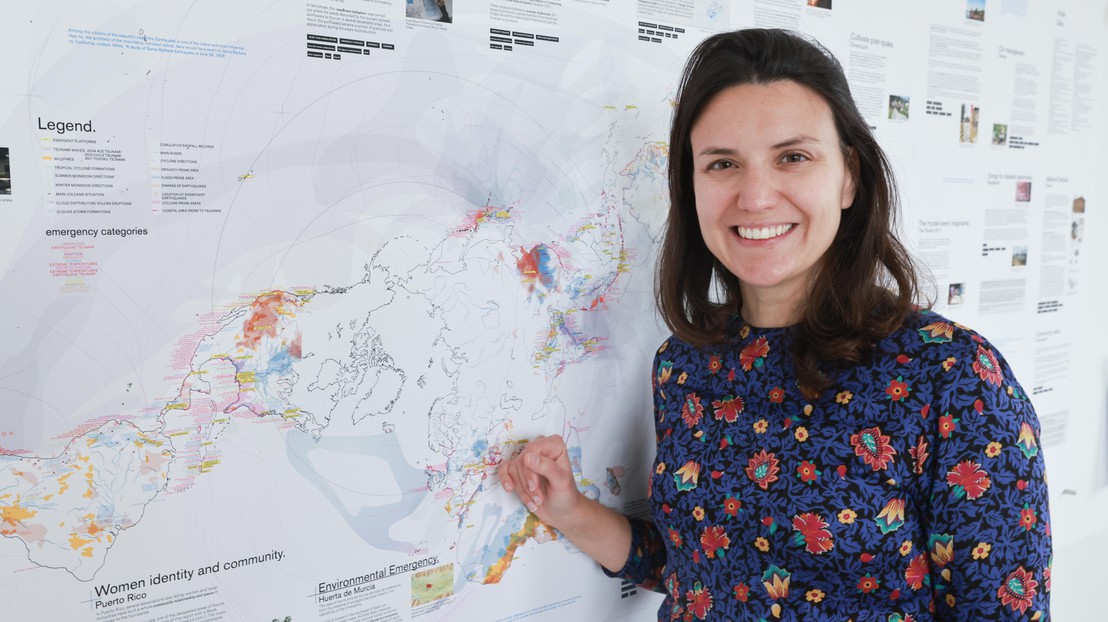 Estefania Mompean Botias in front of a global map of disasters and emergencies © 2022 EPFL, Alain Herzog - CC BY-SA 4.0