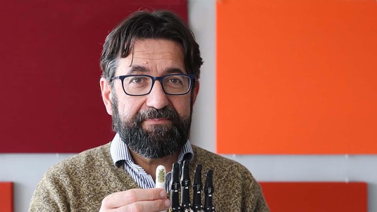 Silvestro Micera holding a thermal sensor on a prosthetic index finger.  2023 EPFL / Alain Herzog - CC-BY-SA 4.0