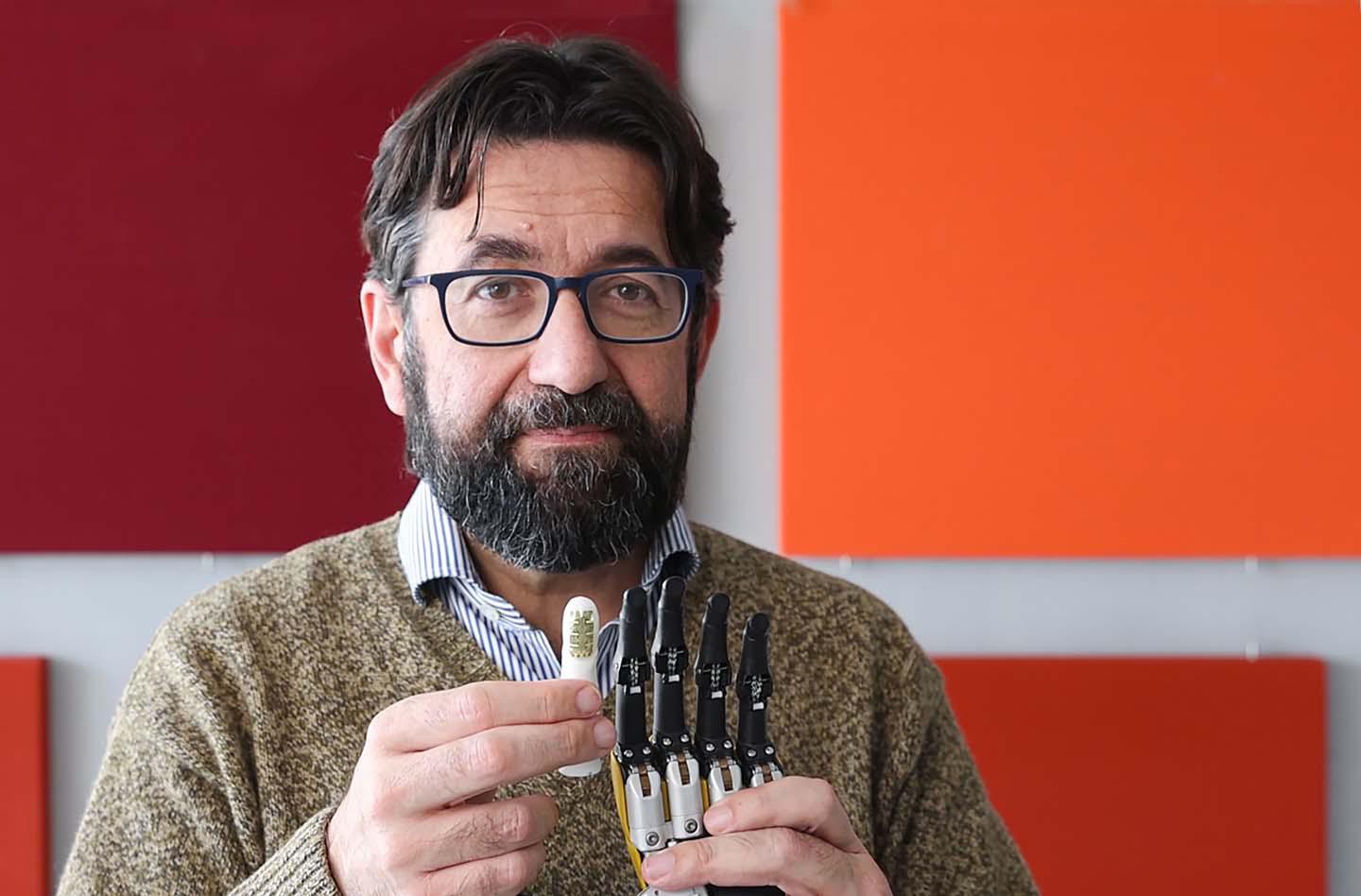 EPFL / Alain Herzog. Silvestro Micera holding a thermal sensor on a prosthetic index finger.