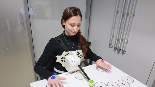 Martina Gini contrôle un bras robotique simplifié avec la respiration. © 2023 EPFL / Alain Herzog, CC-BY-SA