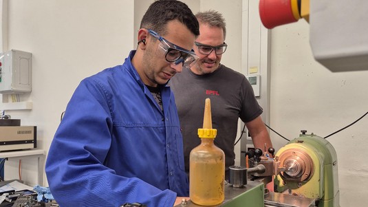 ATPR instructor Stéphane Haldner and a student use a lathe. 2025 PAT EPFL CC BY SA