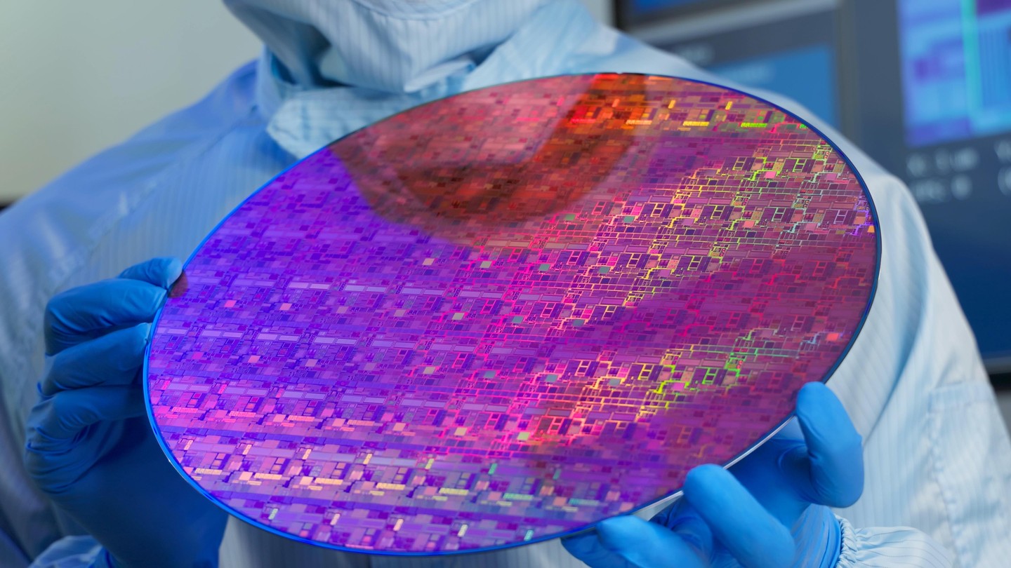 A technician holds a wafer at a semiconductor manufacturing plant © iStock