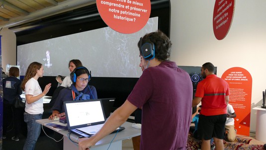 Participants try to guess what chords come next at the digital musicology display © 2019 EPFL
