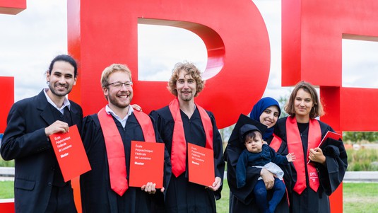 The new graduates in front of the EPFL logo © 2019 Jamani Caillet