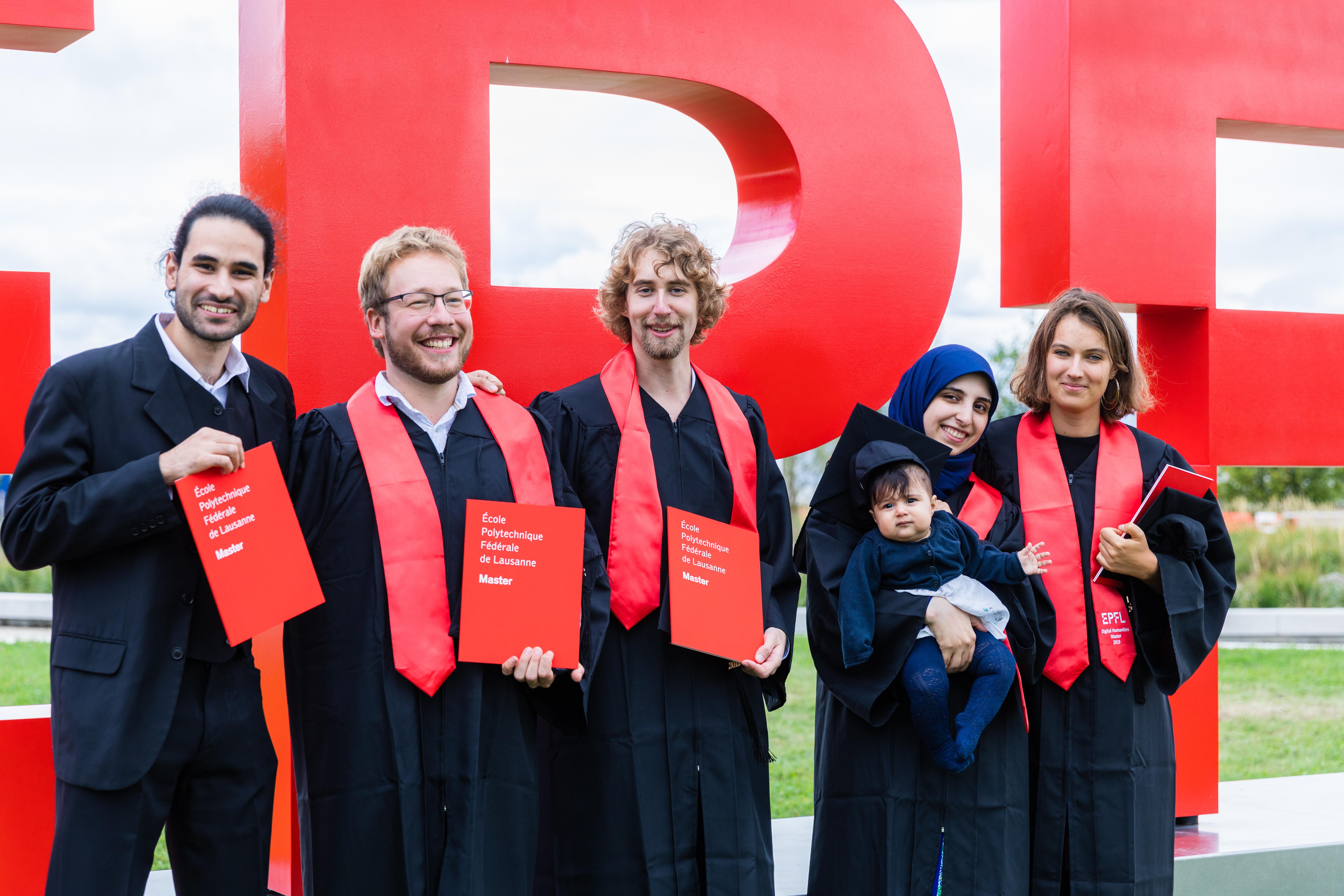 The new graduates pose in front of the EPFL logo © 2019 Jamani Caillet