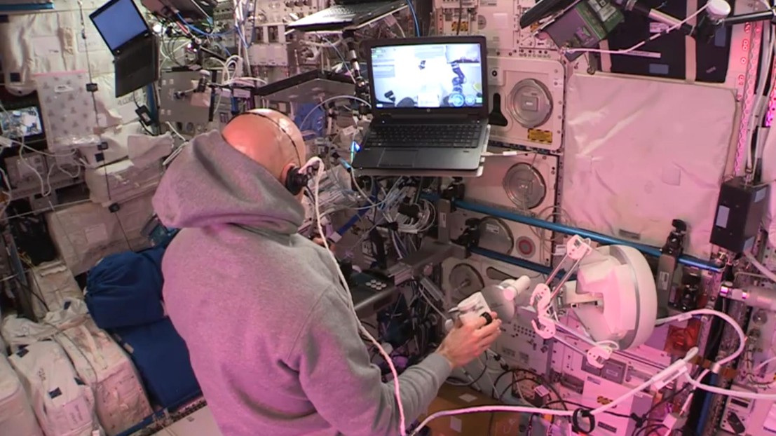 The astronaut Luca Parmitano  uses the haptic plateform to control a robot located on earth©2019 ESA