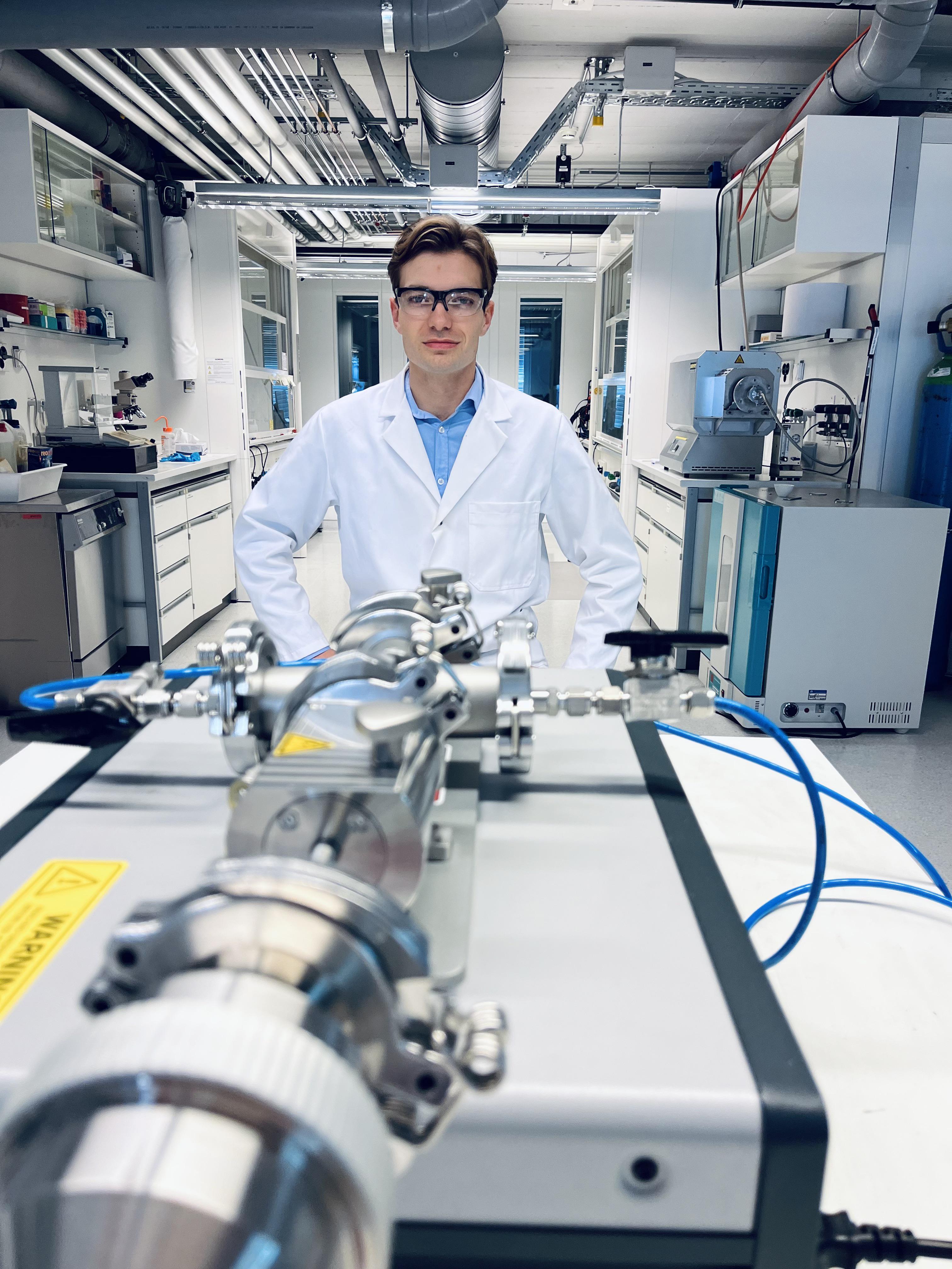 Cedric David Koolen, co-lead-author of the study, posing with the spark ablation device used to generate the clusters in the Laboratory of Materials for Renewable Energy. Credit: EPFL.