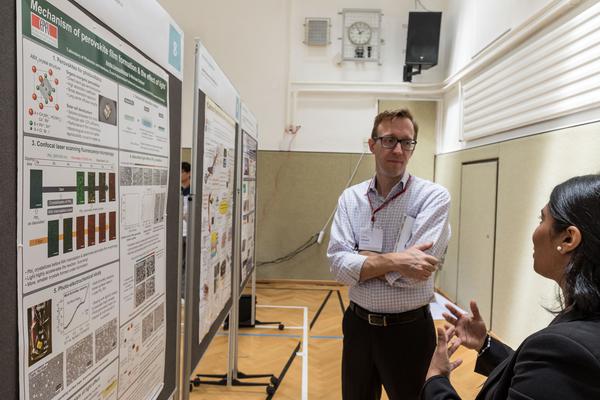 Ummadisingu during the poster session presenting her work on the mechanism of perovskite film formation and the effect of light (to Joshua Schnell of Clarivate Analytics)